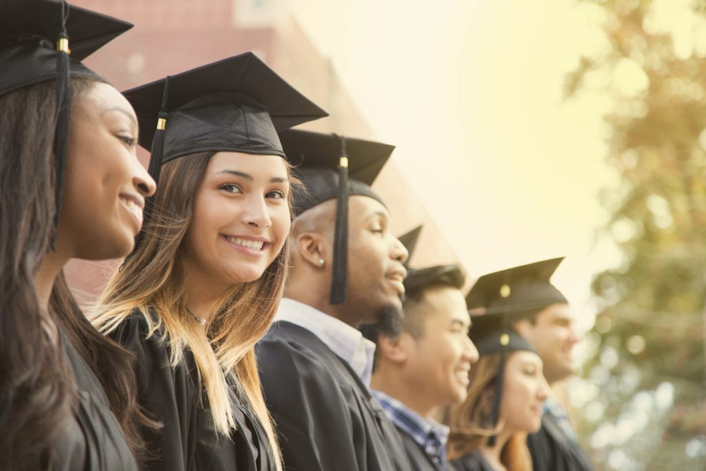 Latin descent female college student graduation on campus.